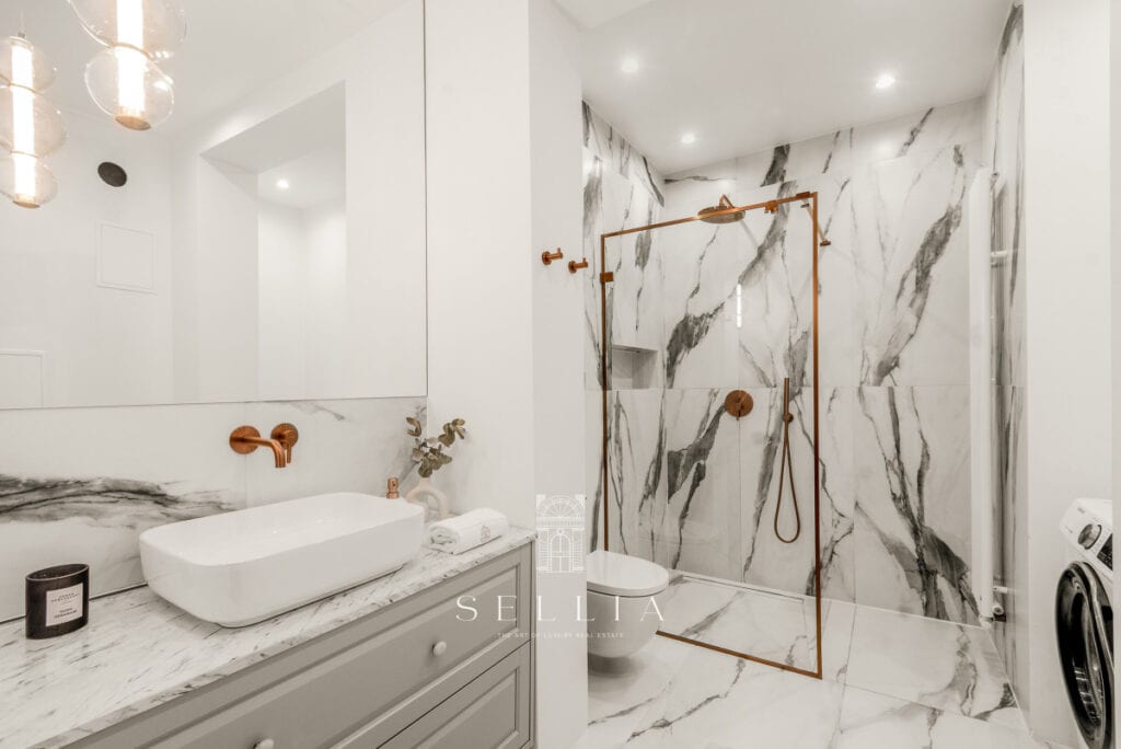 Przestronna łazienka w nowoczesnym stylu z marmurowymi wykończeniami i eleganckim prysznicem. Idealn.
