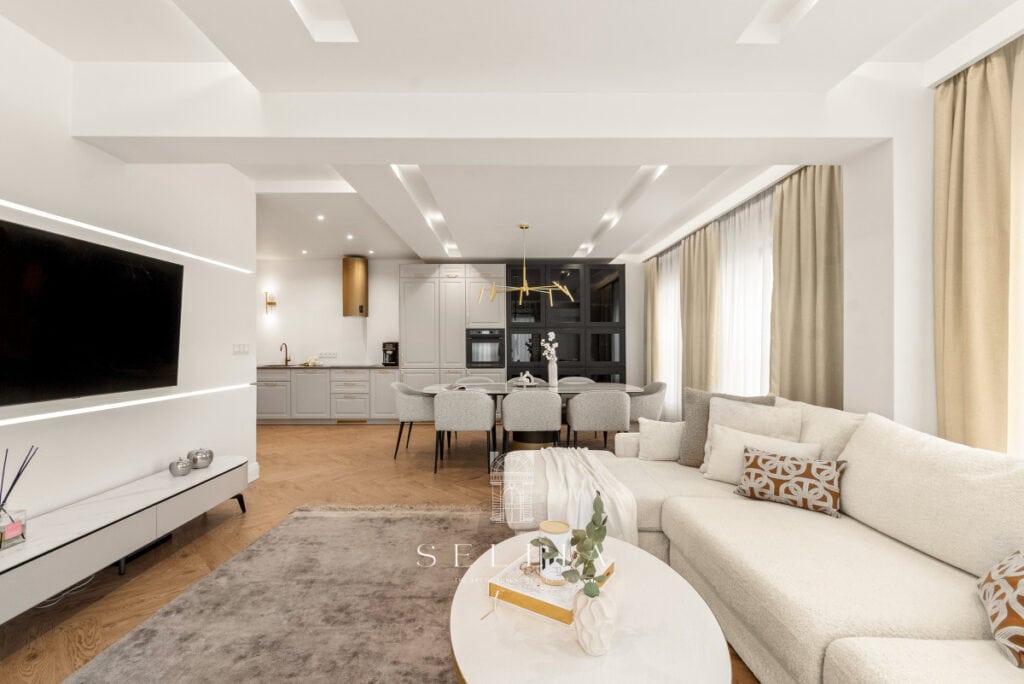 Nowoczesny salon w penthousie Wilanów z dużymi oknami i tarasem.