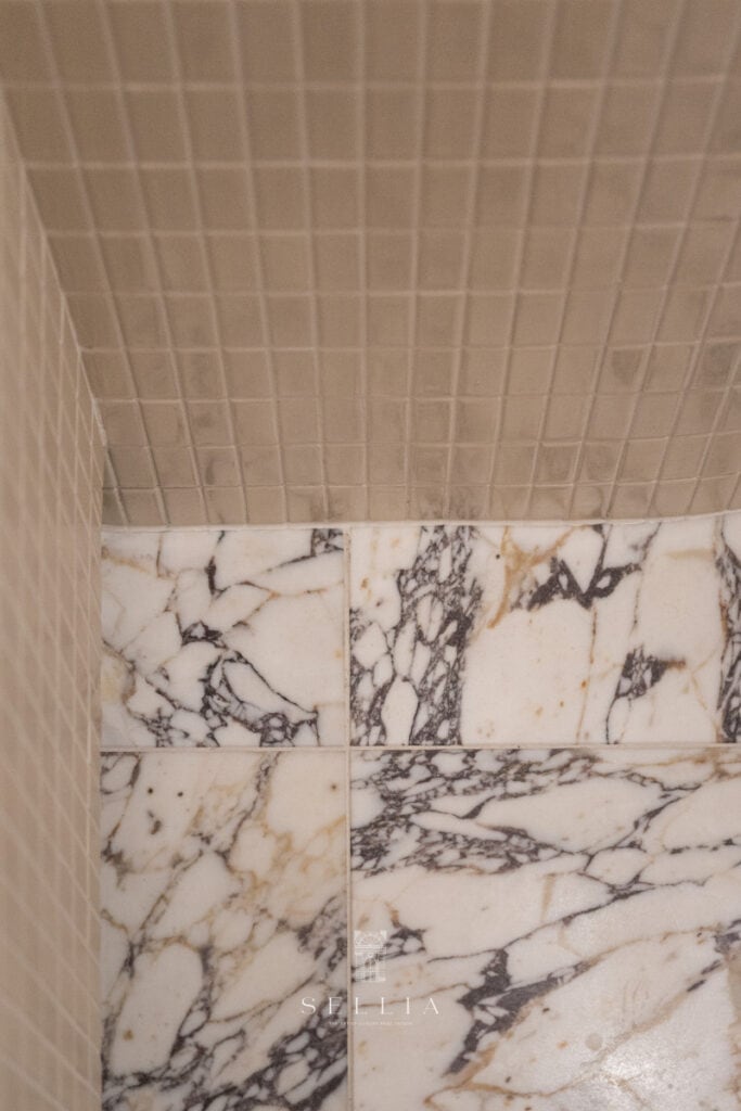 Nowoczesna łazienka z marmurowymi płytkami i eleganckim wykończeniem.