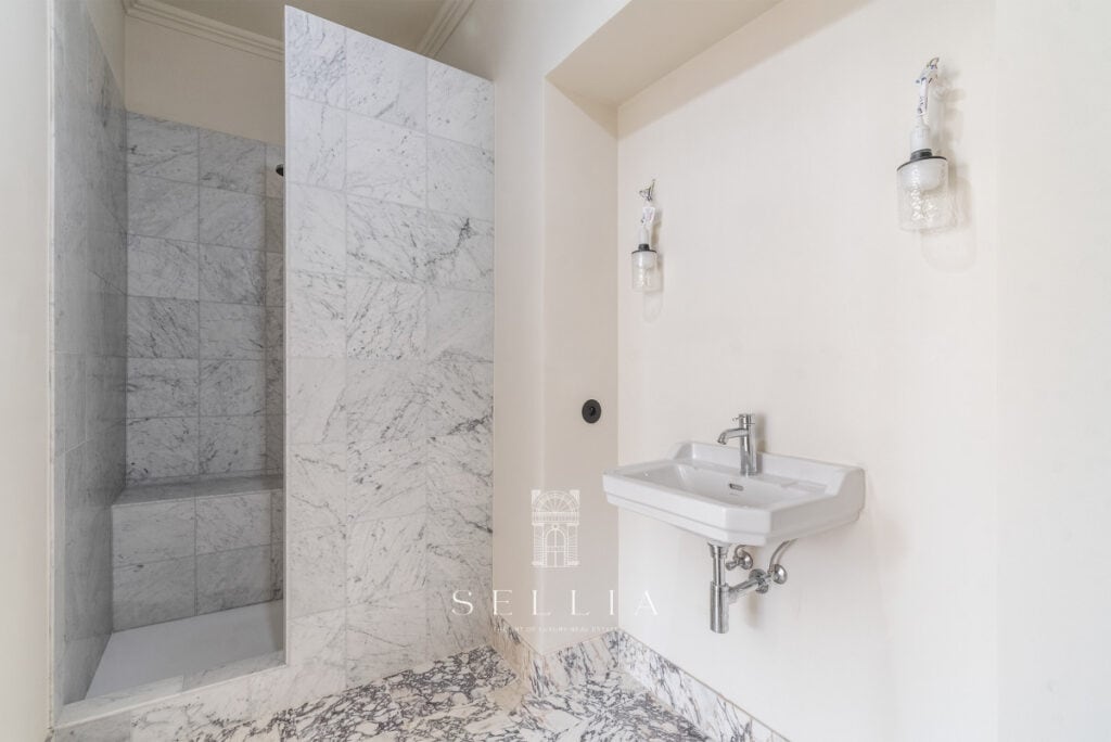 Łazienka w apartamencie na ul. Hoża, z marmurowymi ścianami i minimalistycznym stylem. Idealne miejs.