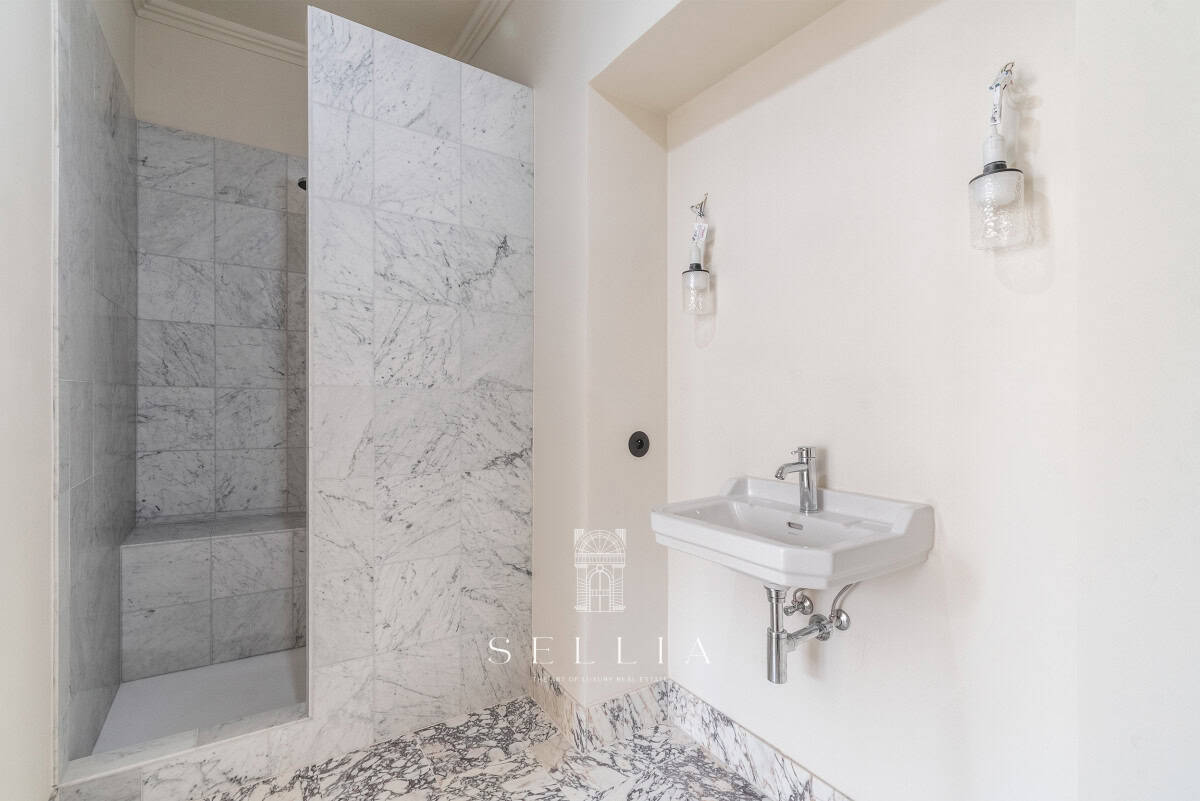 Łazienka w apartamencie na ul. Hoża, z marmurowymi ścianami i minimalistycznym stylem. Idealne miejs.