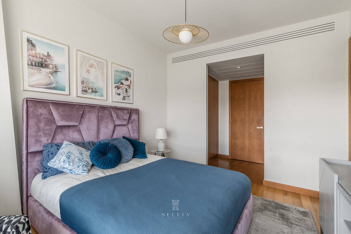 Nowoczesny pokój z łóżkiem i dekoracjami na ścianie w apartamencie z widokiem na PKiN.