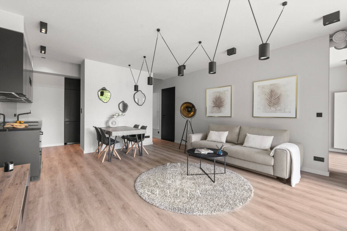 Przestronny, nowoczesny salon z jasnym wykończeniem i balkonem.