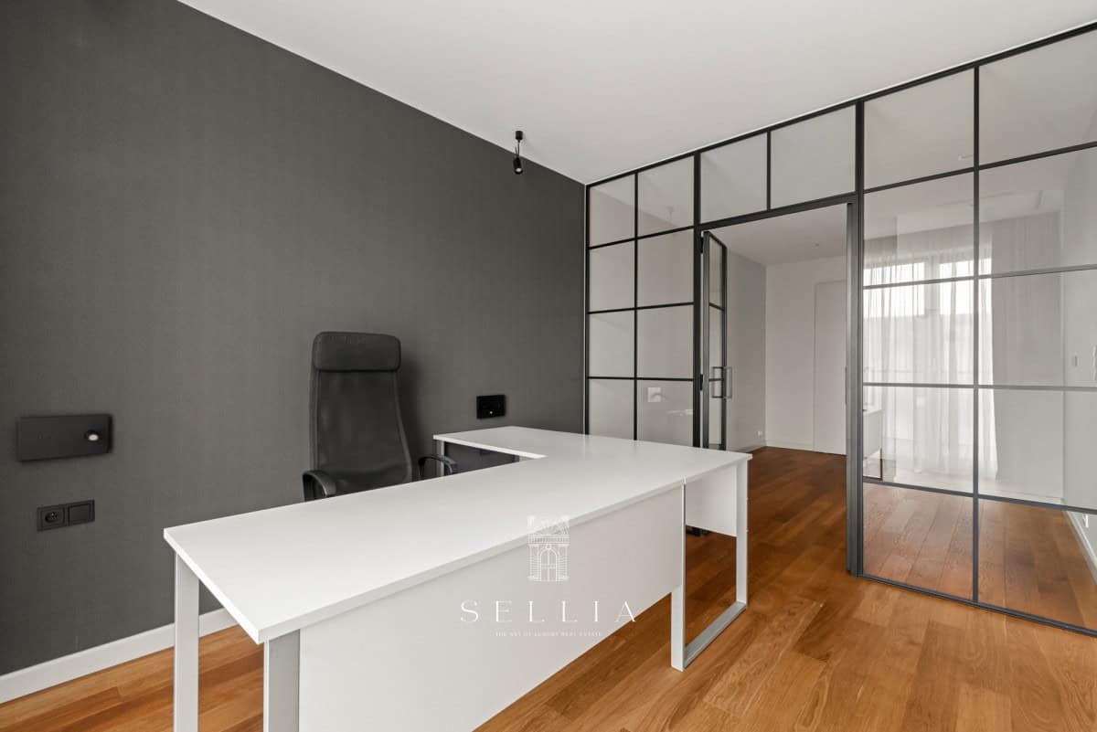 Nowoczesne biuro z białym biurkiem i szarą ścianą w apartamencie w Forcie Cze.