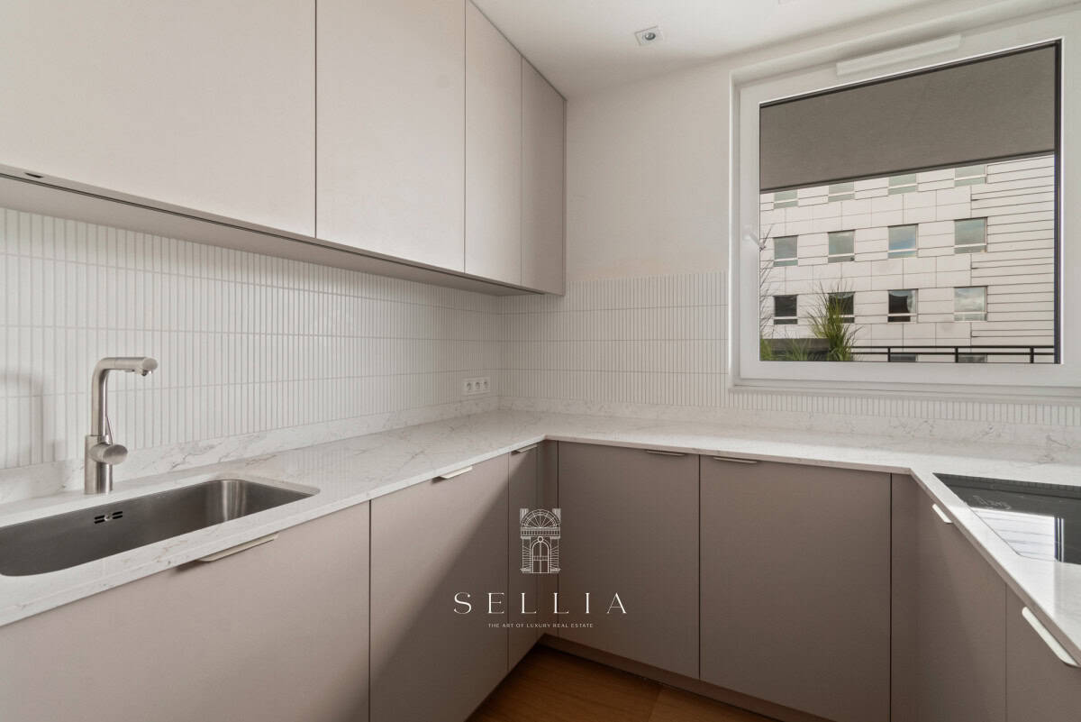 Kuchnia w luksusowym apartamencie z dużym oknem i nowoczesnym wykończeniem.