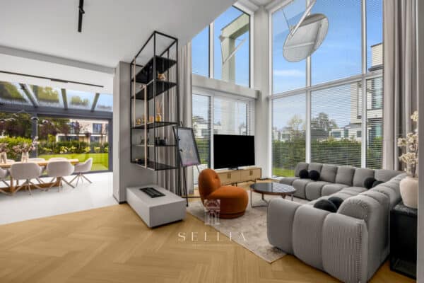 Przestronny salon z dużymi oknami i nowoczesnym wystrojem w Hampton Residence.