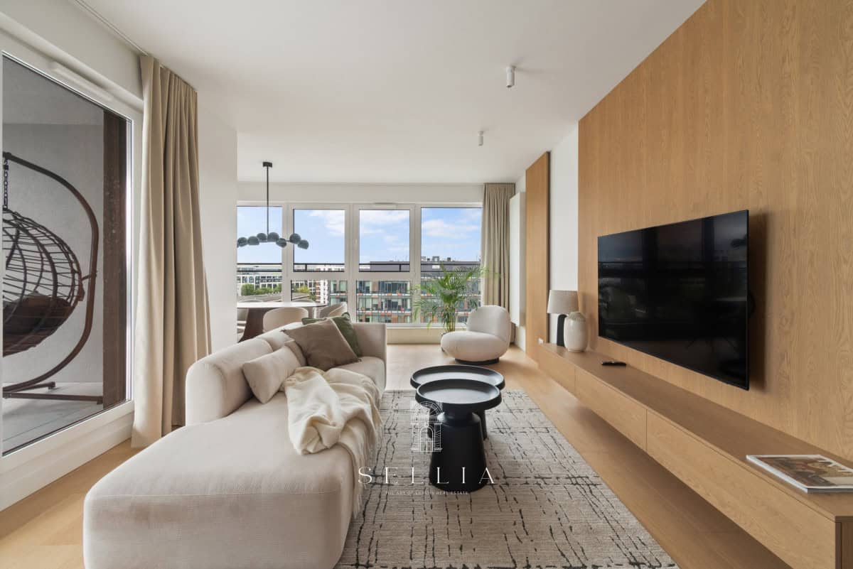 Przestronny salon w luksusowym apartamencie z tarasem i panoramicznym widokiem.