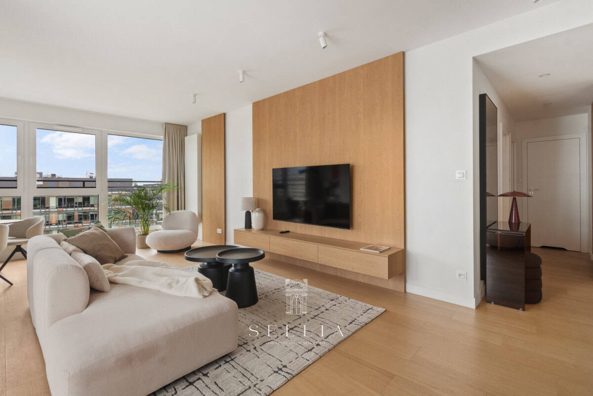 Nowoczesny salon z dużym telewizorem i komfortową sofą w luksusowym apartamencie.
